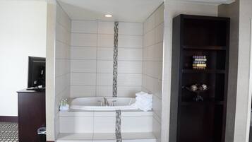A modern bathroom with a freestanding bathtub, a vanity, and a shelf with toiletries.
