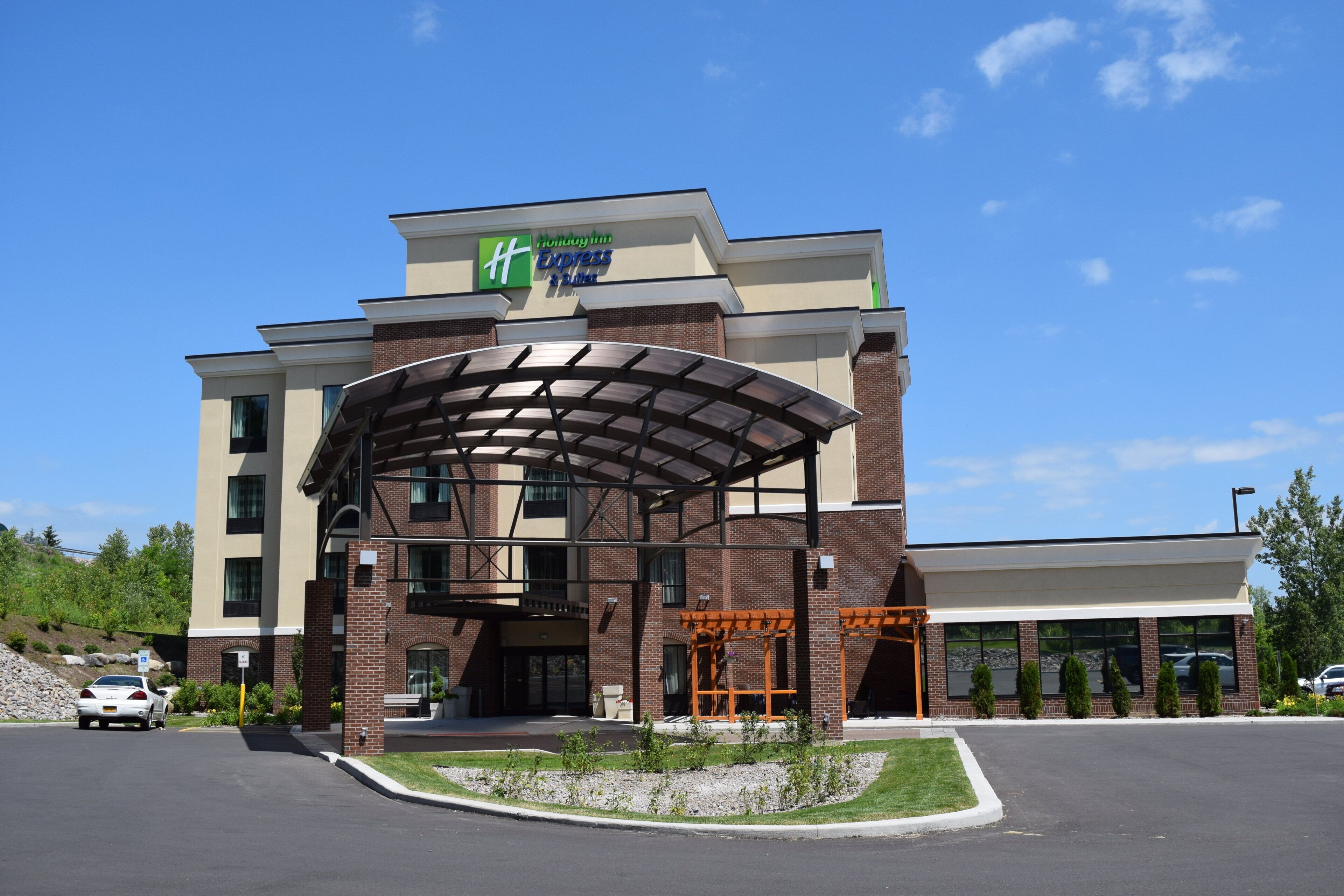 A Holiday Inn Express & Suites hotel with a covered entrance and a parking lot.