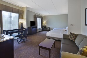 A hotel room with a bed, a desk with a computer, a chair, a small table, and a lamp. - Holiday Inn Express & Suites Geneva Finger Lakes by IHG (Geneva)