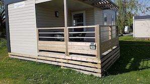 A small, single-story wooden structure with a porch, a door, and a window. - Nordsjællands Feriepark & Camping (Alsgarde)