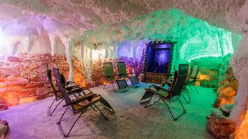 Interior de una cueva de hielo con asientos y una escultura de hielo central.