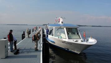 A boat docked at a pier with passengers boarding.