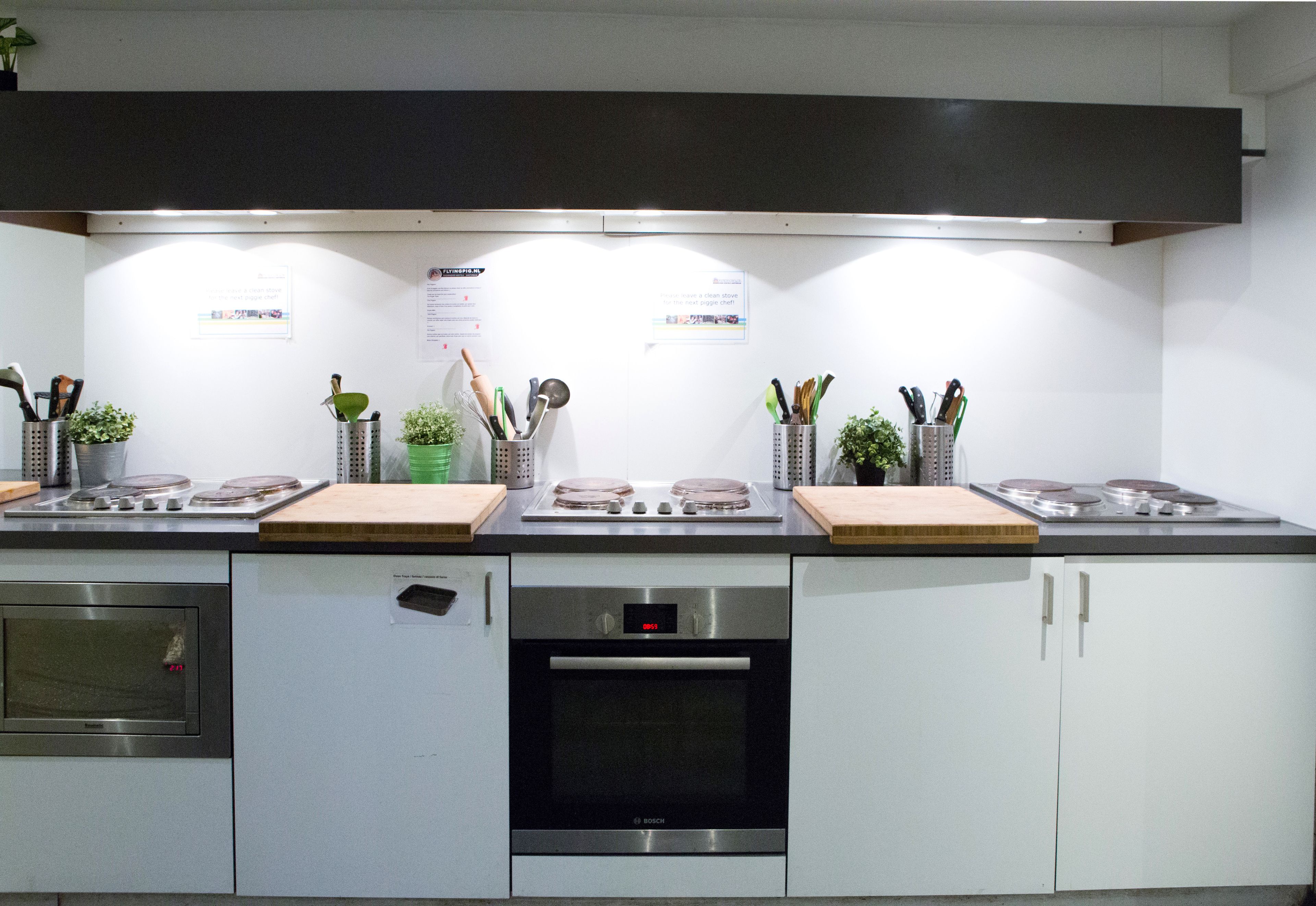 A modern kitchen with stainless steel appliances, wooden countertops, and a range hood.
