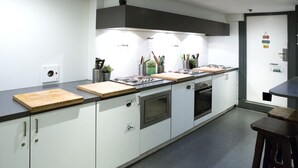 Une cuisine moderne avec des armoires blanches, un plan de travail noir et un four encastré.