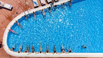 Relax by the pool surrounded by lounge chairs and sunbeds.