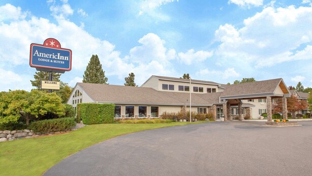 An American Inn with a welcoming sign, a covered front porch, and a well-maintained lawn.