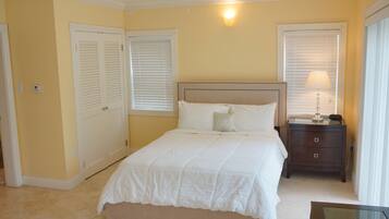 A bedroom with a bed, a nightstand, a lamp, and a ceiling fan.