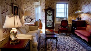 Una sala de estar tradicional con un sofá, sillones, una mesa de centro y una alfombra estampada.