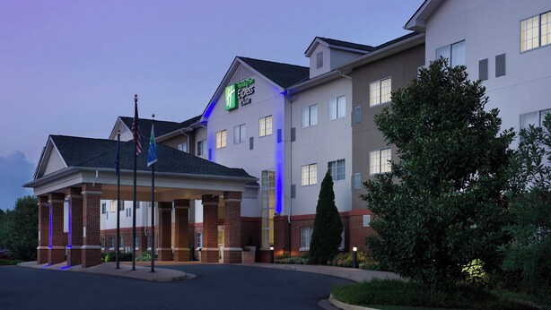 A Holiday Inn Express hotel with a brick facade, a covered entrance, and a well-lit exterior.