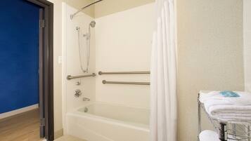 Un baño con bañera, ducha y un perchero para toallas.