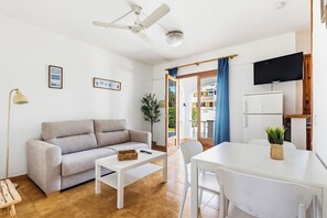 Una sala moderna con sofá, mesa de centro y comedor con mesa y sillas.