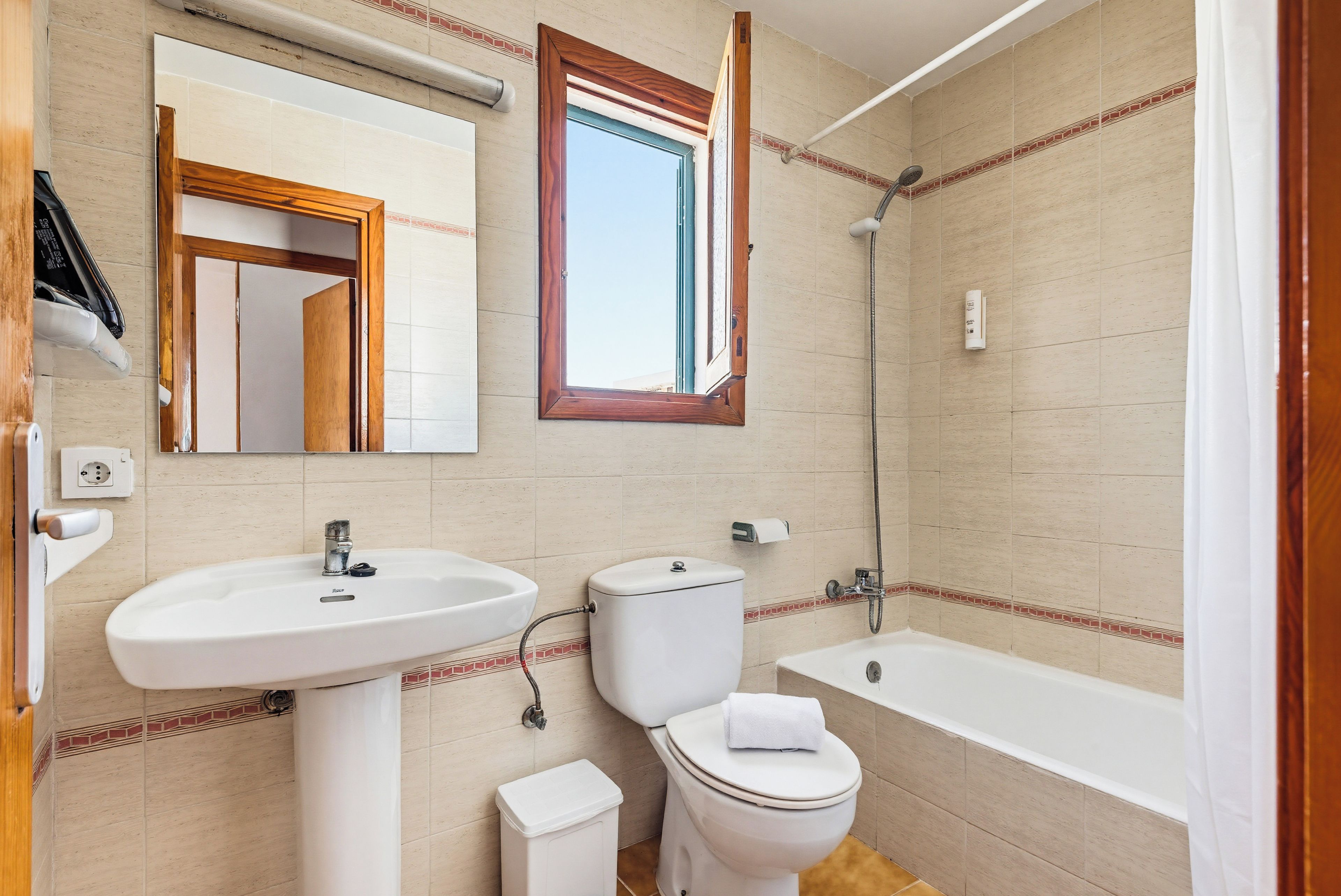 Un baño con lavamanos, inodoro y bañera.
