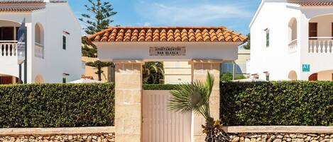 A gated entrance with a sign reading 'Apartamentos Mar Blanca.'