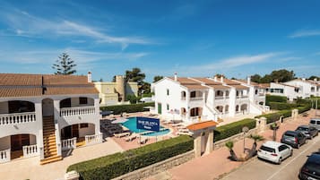 Área residencial com piscina, vários edifícios com varandas e céu limpo.