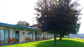 Een motel met een rij eenpersoonskamers, elk met een raam en een deur.