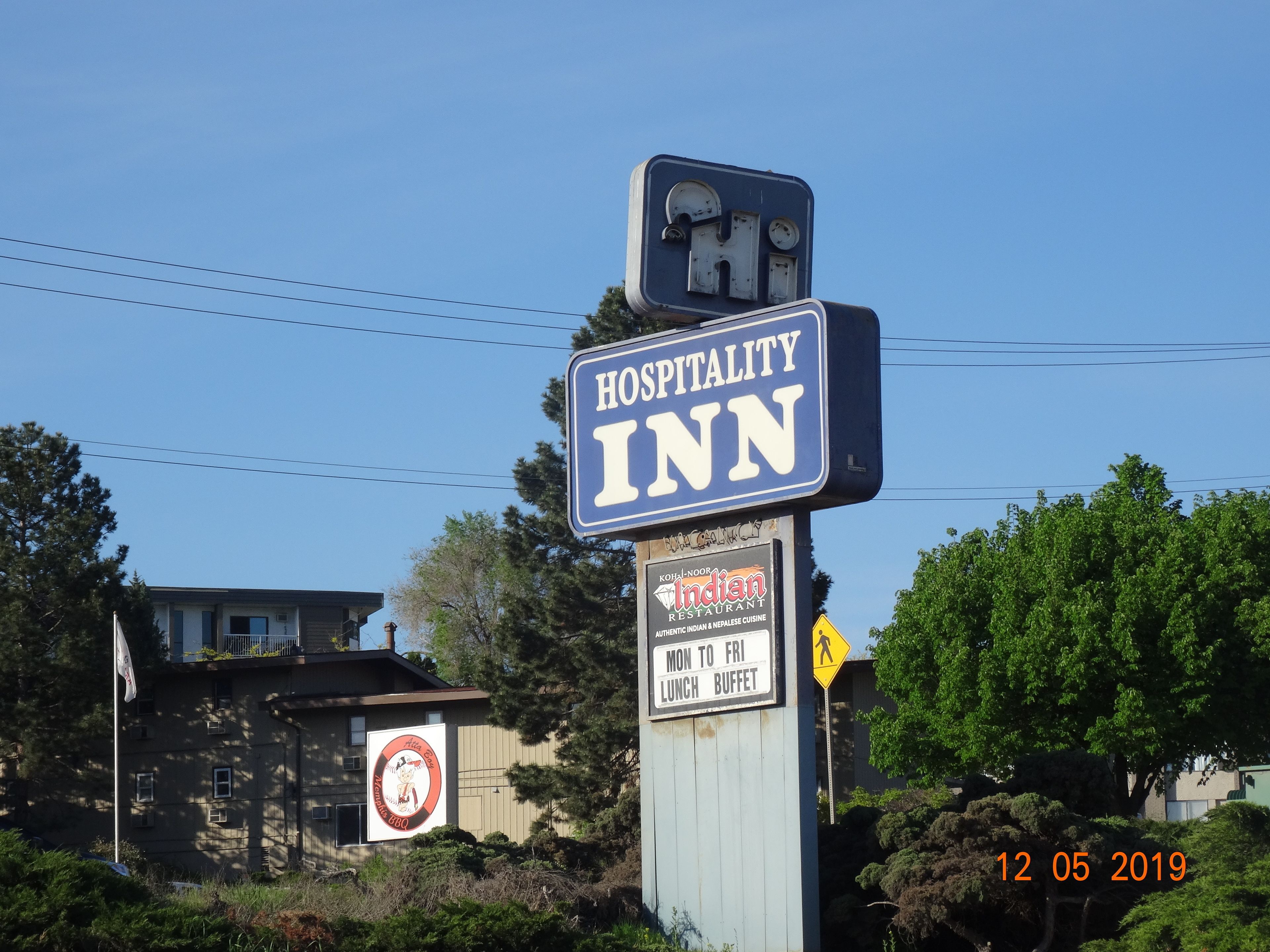 A sign for Hospitality Inn with a sub-sign for Indian Restaurant.