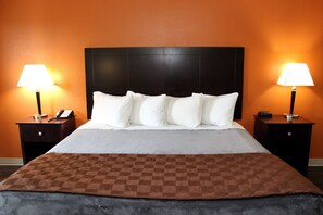 A hotel room with a large bed, two bedside tables, and two lamps. - Scottish Inns Killeen near Fort Cavazos (Killeen)