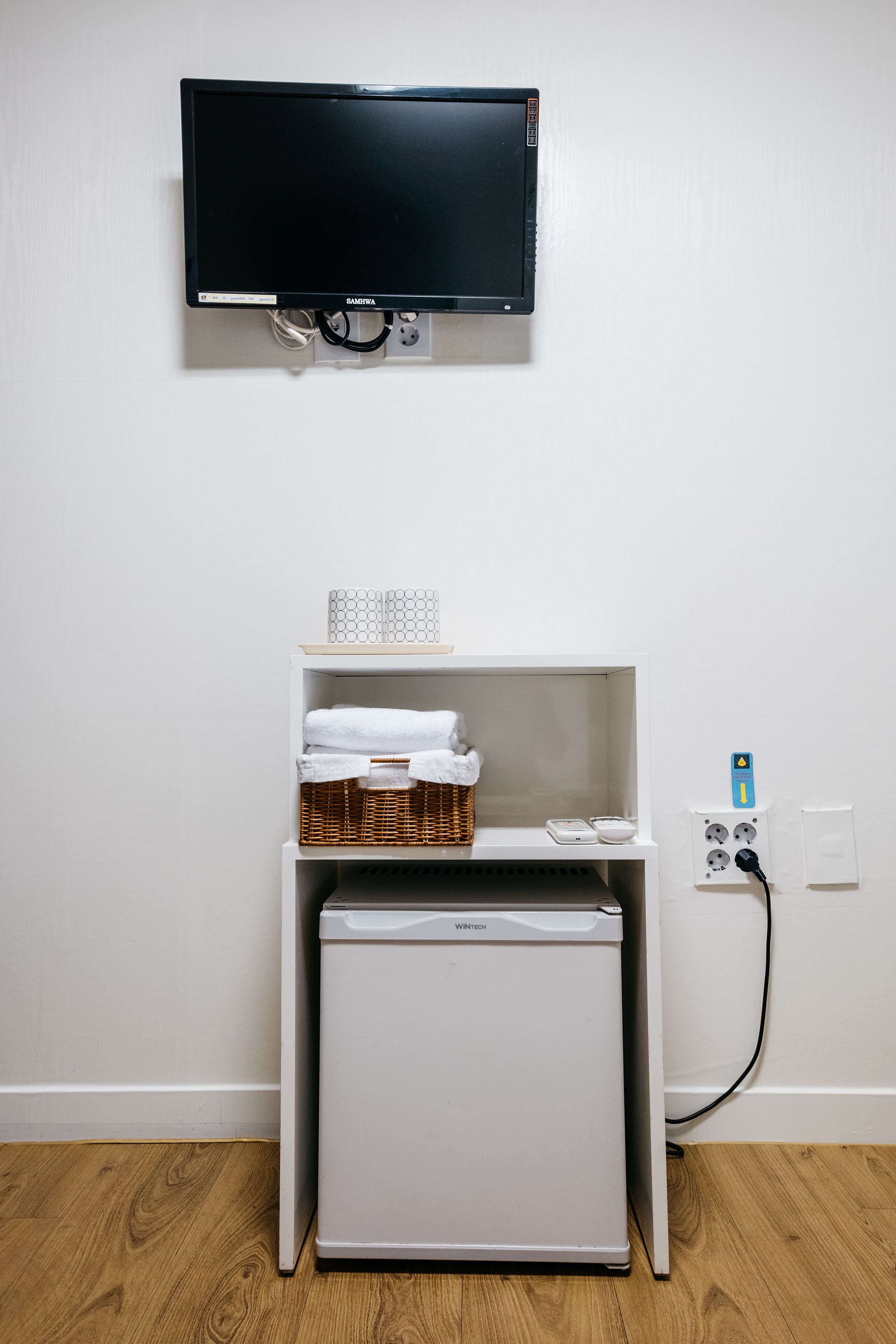A small kitchenette with a white refrigerator, a microwave, and a sink.