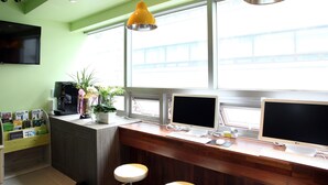 A modern office space with two computer monitors, a desk, and a window with a view of a bridge.