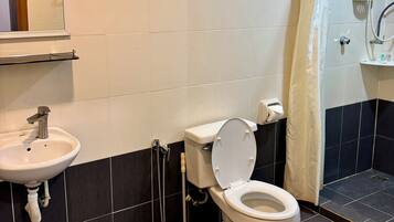 Un baño con inodoro, lavabo, ducha y ventana con persianas.
