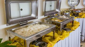 Un'area buffet con diversi cibi e un lavello con rubinetto.