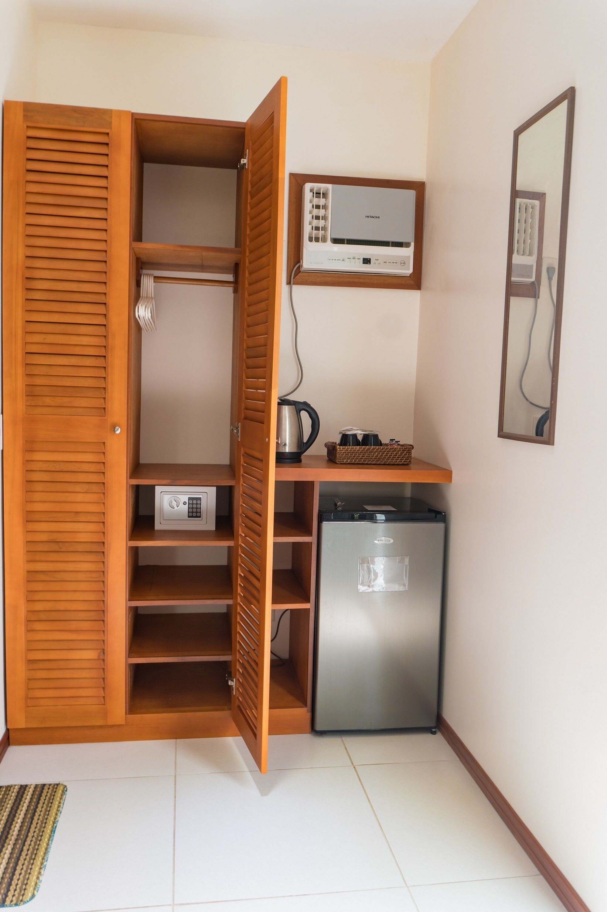 Una kitchenette compacta con refrigerador integrado, cafetera y microondas.