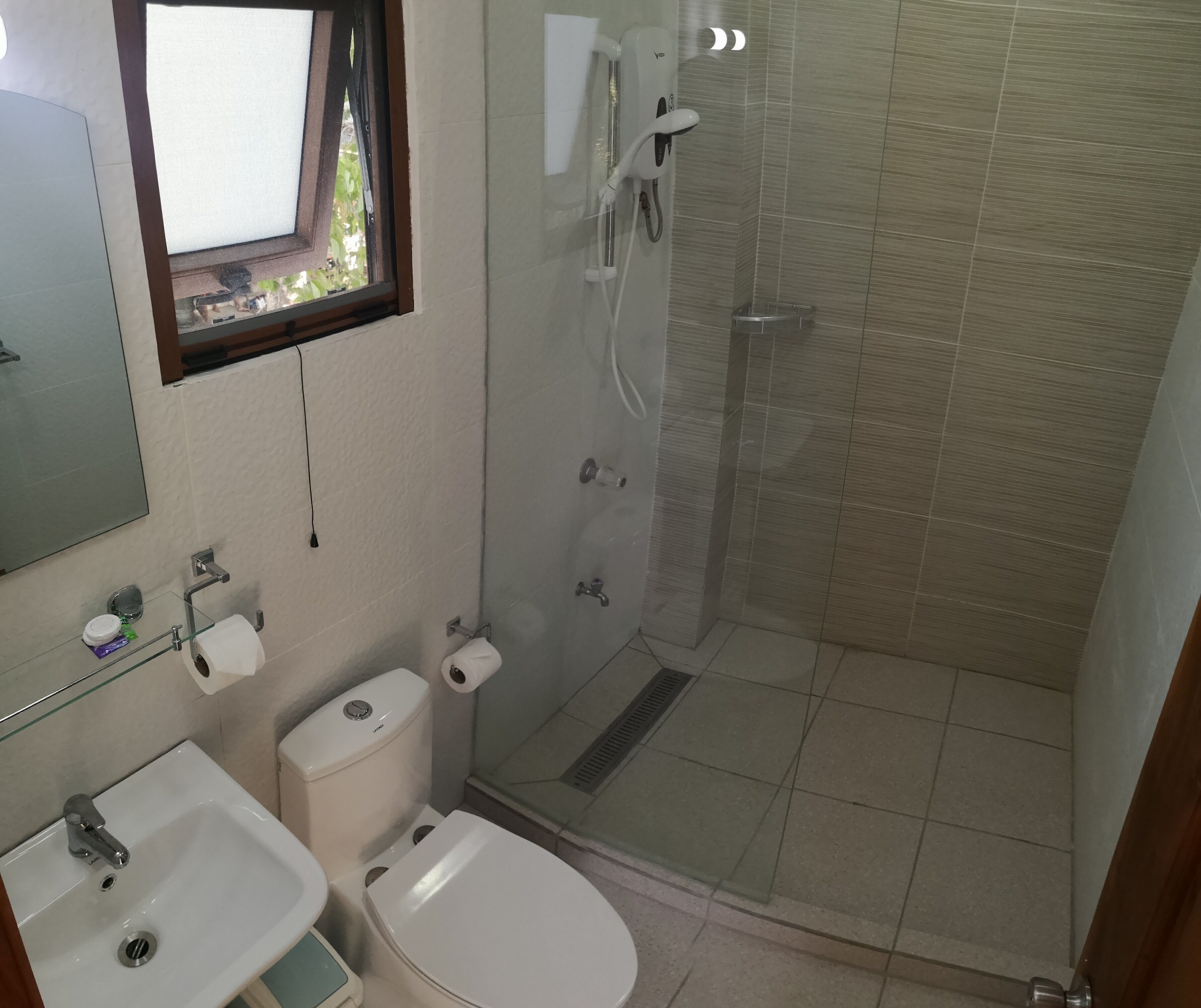 A bathroom with a toilet, sink, and shower.