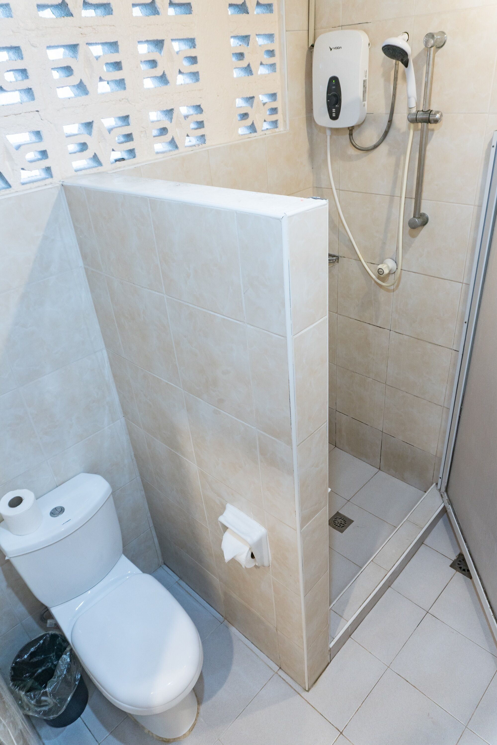 Un baño con inodoro, ducha y secador de manos.