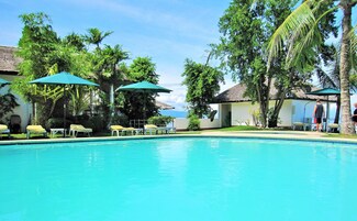 Una piscina al aire libre, tumbonas