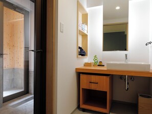 A modern bathroom with a wooden vanity, a large mirror, and a sink. - Yunogo Grand Hotel (Mimasaka)