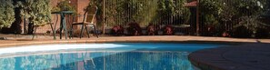 Una piscina al aire libre de temporada, sillones reclinables de piscina