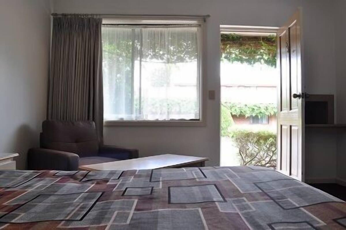 Tempat tidur Select Comfort, meja kerja, dan tirai kedap cahaya