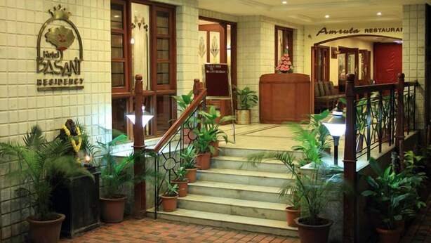 A hotel lobby with a staircase, potted plants, and a sign for 'Amruta Restaurant'. - Hotel Basant Residency (Bengaluru)
