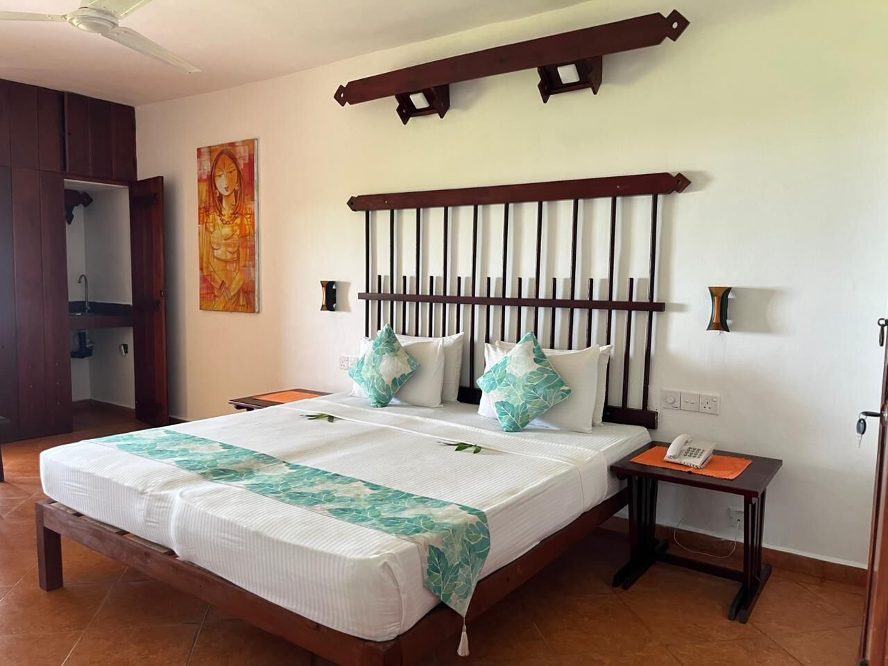 Un dormitorio con cama, mesita de noche y cabecera de madera.