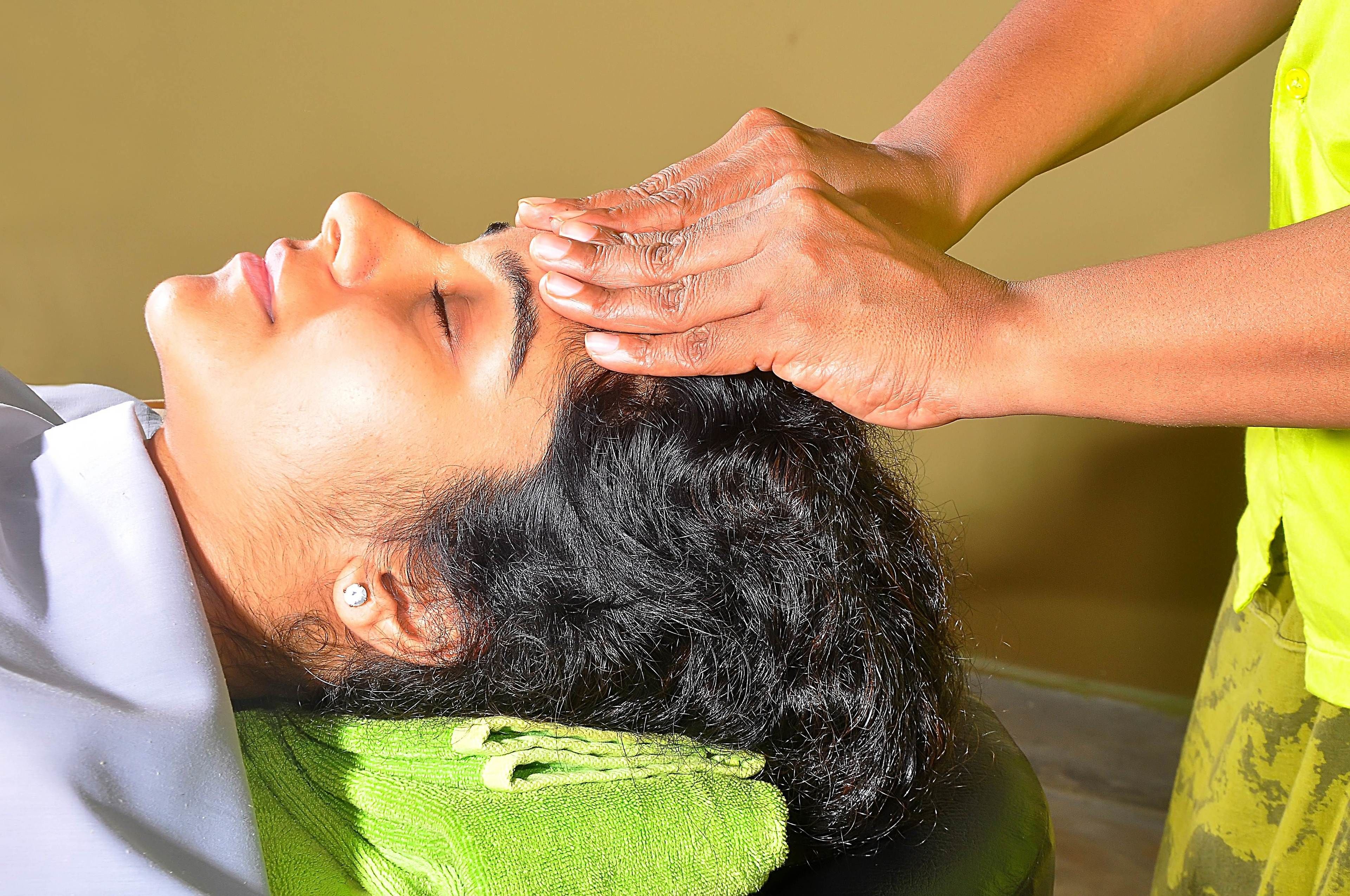 A person receiving a head massage.