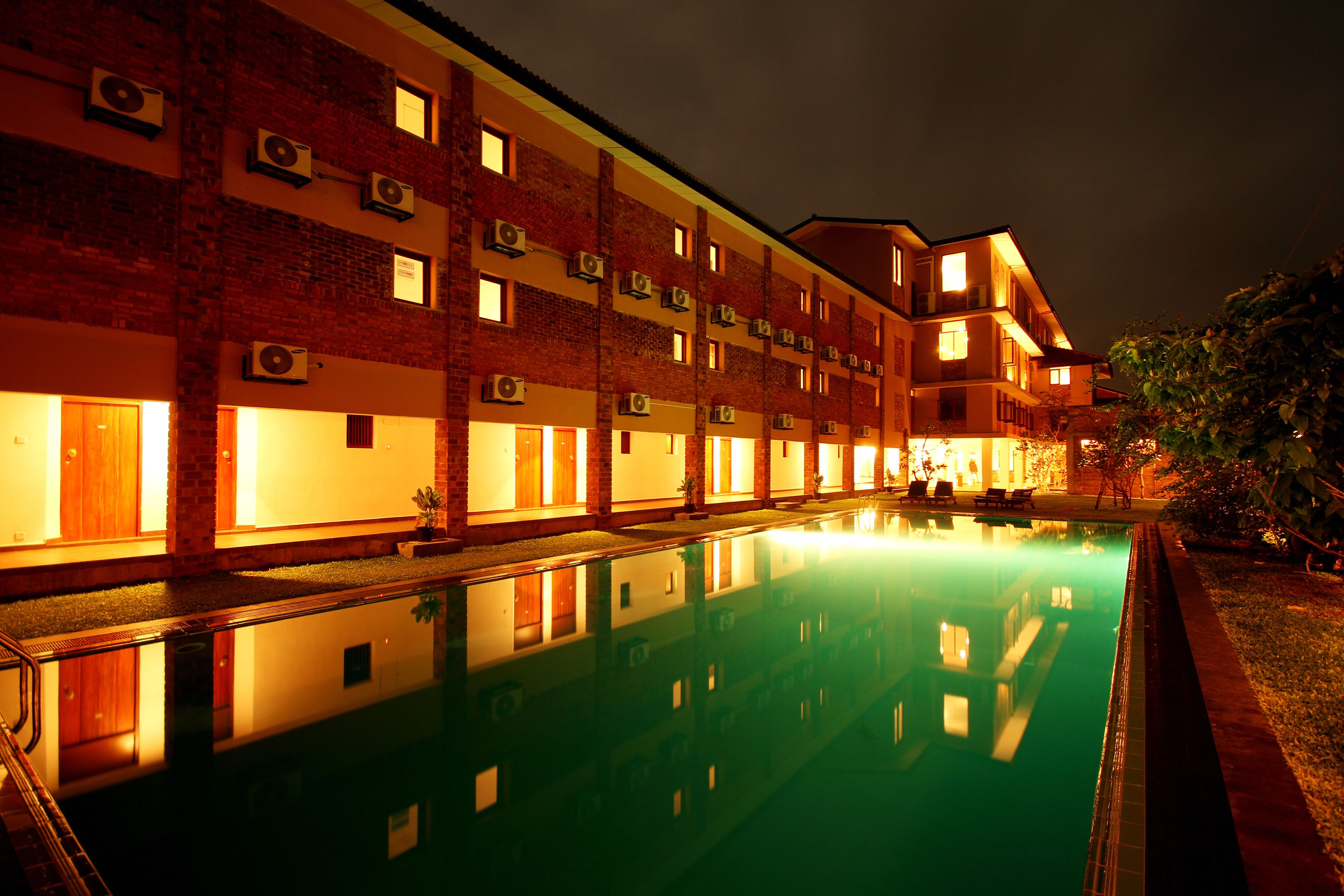 A multi-story hotel with a swimming pool in the foreground.