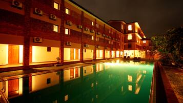 A multi-story hotel with a swimming pool in the foreground.