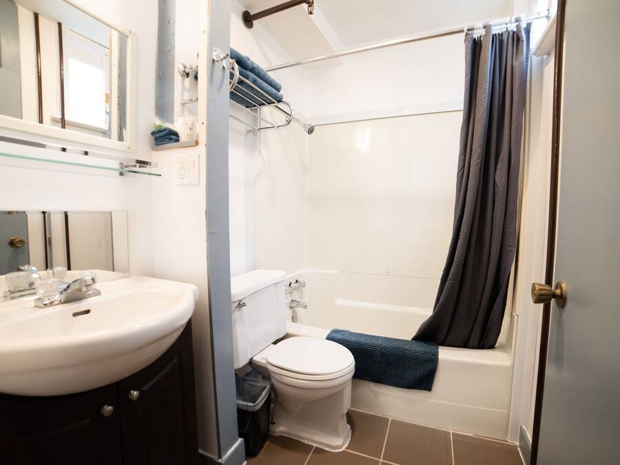A bathroom with a sink, toilet, bathtub, and a shower curtain.