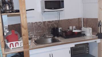 A compact kitchen with a microwave, sink, and basic appliances.