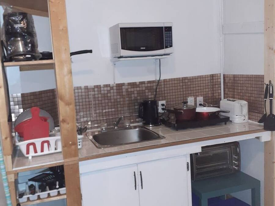 A compact kitchen with a microwave, sink, and basic appliances.