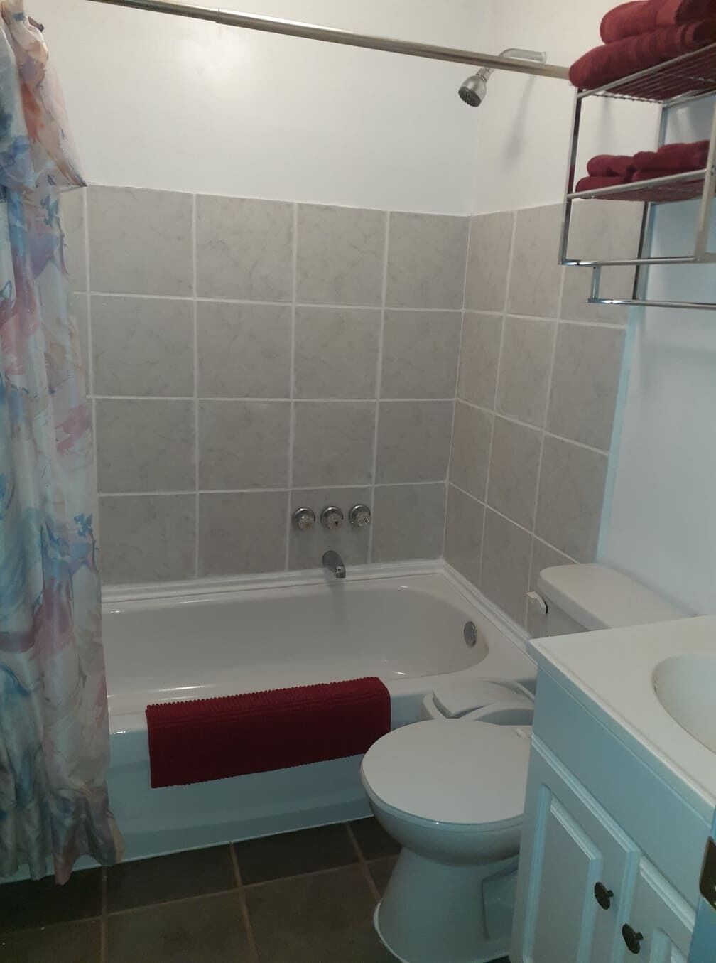 A bathroom with a bathtub, toilet, and a shower area.