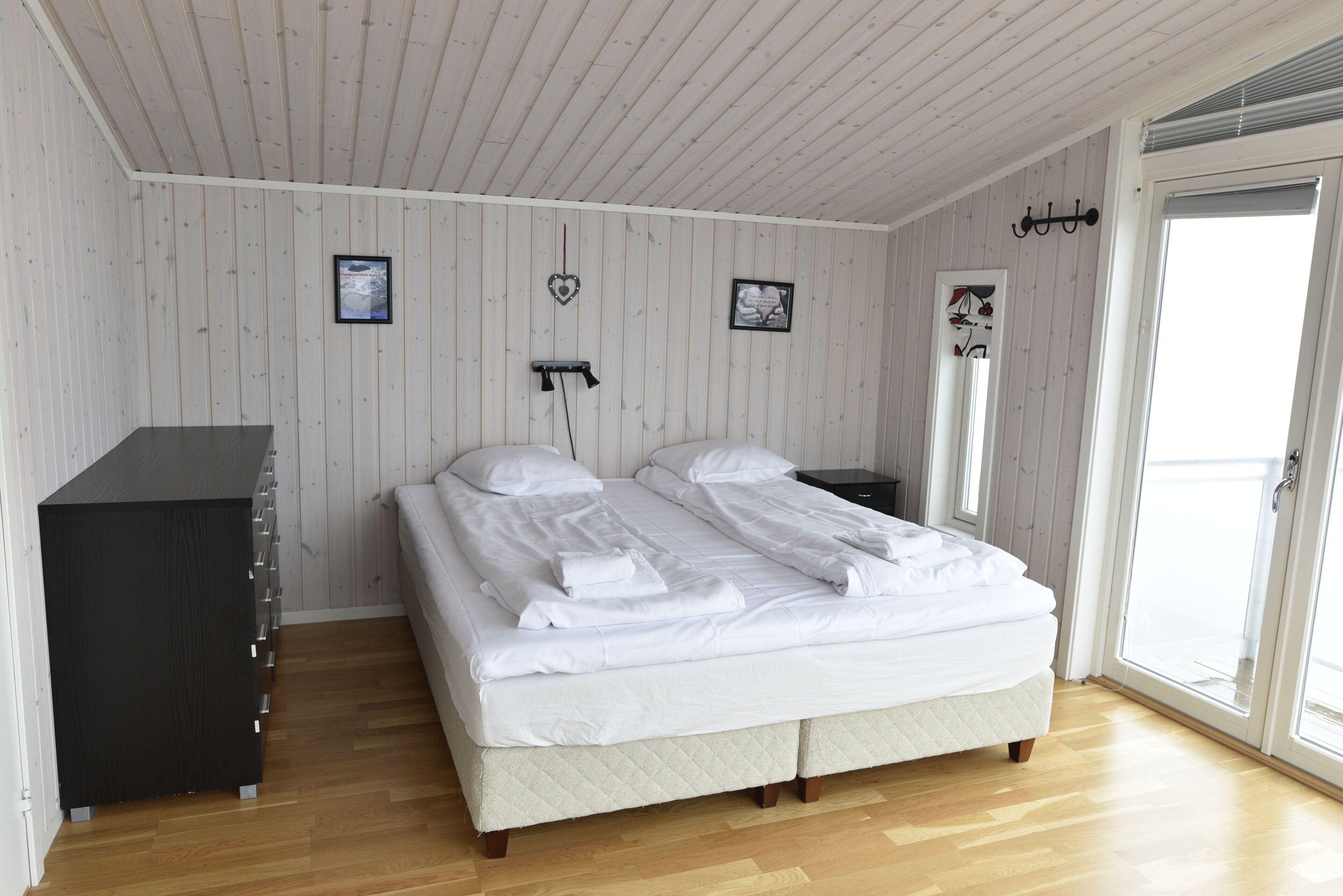 A bedroom with a bed, a dresser, and a window.