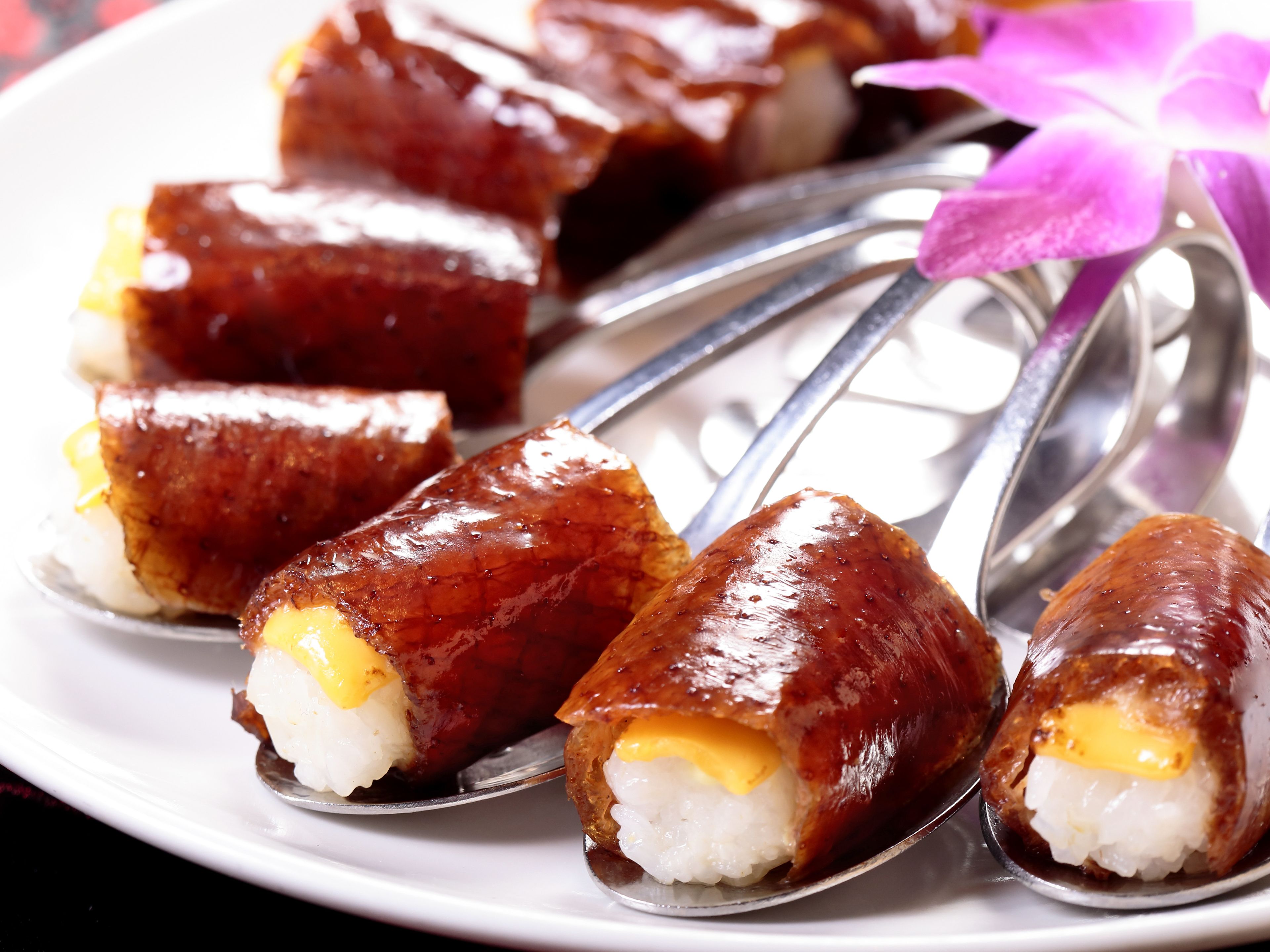 A plate of sushi with a decorative purple flower.