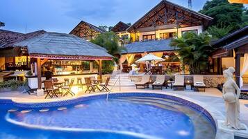 Una piscina al aire libre, sombrillas, tumbonas