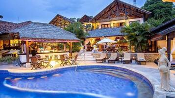 Een buitenzwembad, parasols voor strand/zwembad