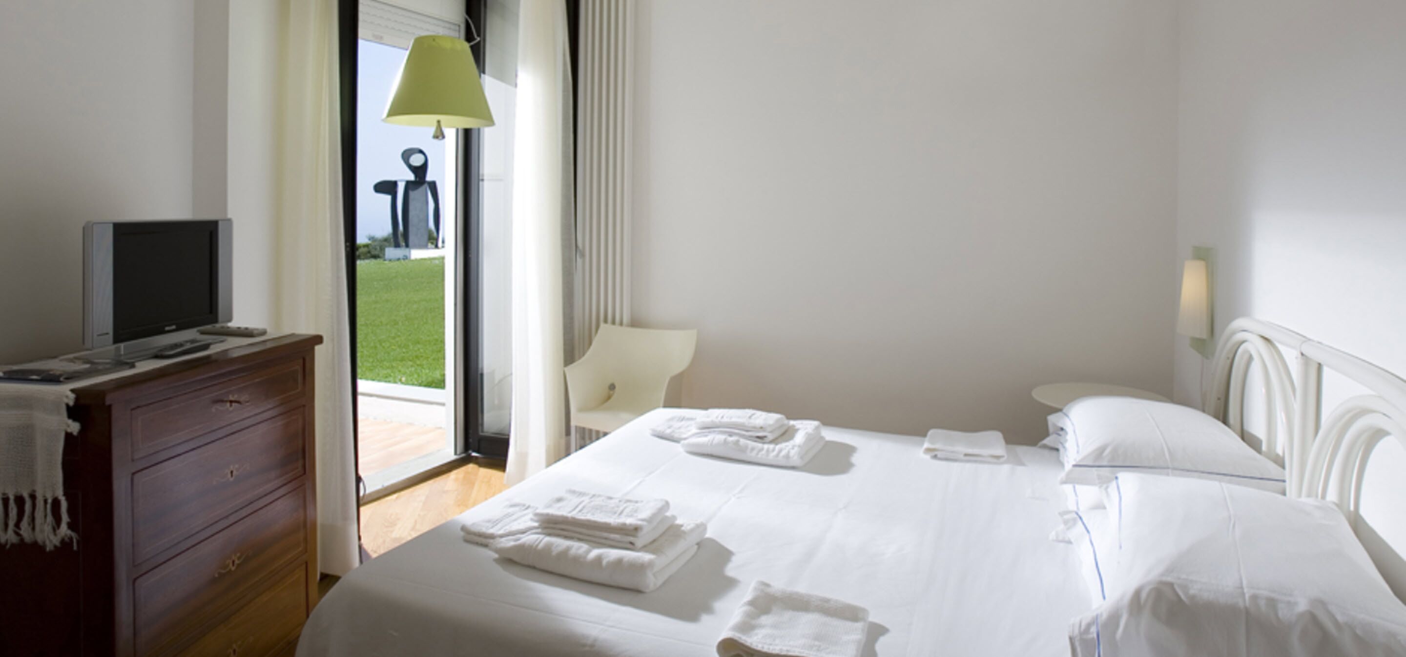 Une chambre d’hôtel avec un lit, une télévision, un bureau et une chaise.