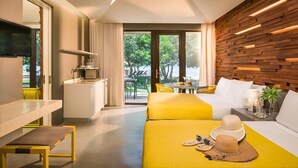A modern hotel room with a bed, a dining table, and a kitchen area. - Astoria Palawan (Puerto Princesa)