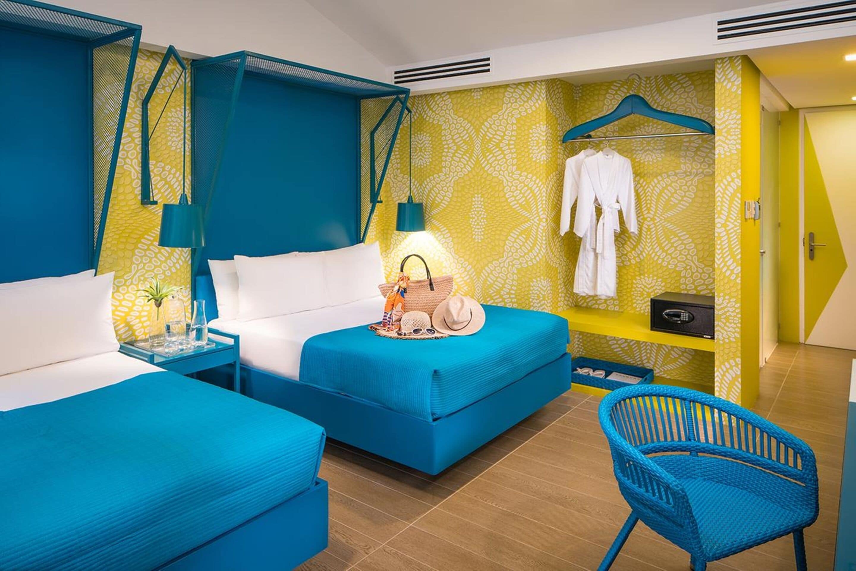 A hotel room with a bed, a bedside table, a chair, and a wardrobe.