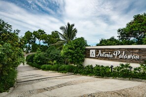 Un camino que lleva a un edificio con un letrero que dice 'Astoria Palawan'.
