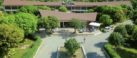A hotel with a central courtyard, outdoor seating, and a pool.
